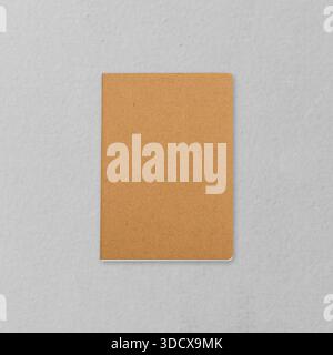 Top view of a simple brown kraft notebook on a light grey surface. Great for mockup or copy space presentations, background design, writing projects, Stock Photo
