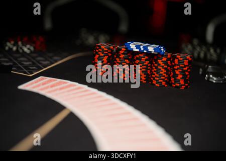 Professional casino poker table detail with organized chip stacks and curved card spread, illustrating live gambling setup and gaming industry environ Stock Photo