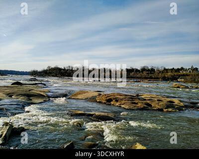 Powerful river current flowing over large smooth rocks Stock Photo