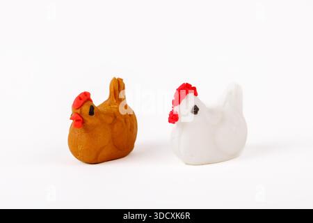 Two handmade marzipan chicken figurines, one white and one brown, isolated on white background. Stock Photo