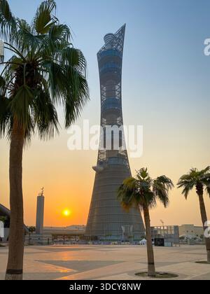 Doha, Qatar ? September 29, 2019: The Torch Tower in Doha Sport City Complex at sunset next to Aspire Masjid Mosque against clear sky Stock Photo