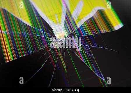 Close-up view of a broken electronic device screen showing extensive damage with bright multicolored vertical lines and sharp cracks, conveying system Stock Photo