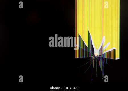 Close-up view of a shattered LCD screen featuring a prominent central impact point and vibrant colorful vertical lines, illustrating technological fai Stock Photo