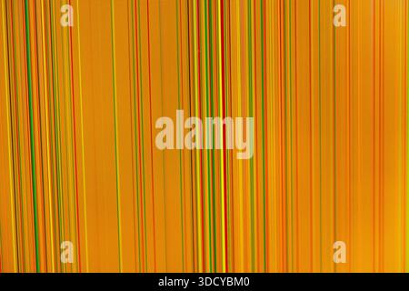 Close-up orange digital display featuring numerous thin red, green, yellow, black vertical lines, conveying malfunctioning screen or visual data disto Stock Photo