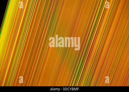 Close up of abstract vibrant diagonal lines pattern in colorful yellow, orange, red, green hues, representing dynamic digital data flow, ideal for fut Stock Photo