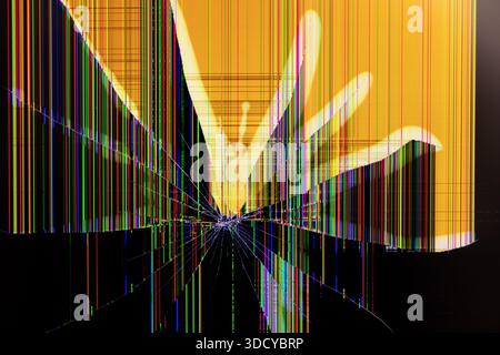 Close-up of a damaged liquid crystal display with a shattered impact point, spreading multi-colored pixels and lines across a disrupted yellow backgro Stock Photo