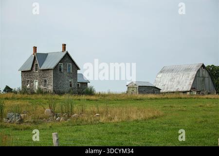 Abandoned farmhouse and barn on the Bruce Peninsula, Canada. Rural heritage in serene countryside landscape. Stock Photo