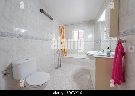 Residential Bathroom Interior with Tiled Walls and Bathtub in holiday home Stock Photo