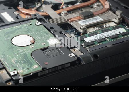 Wide-angle shot of an open laptop revealing the position of the Hard Disk Drive (HDD) and RAM slots. Ideal illustration for storage upgrade articles o Stock Photo