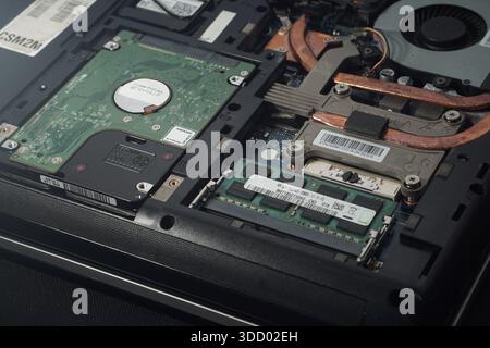 Exposed laptop machinery displaying vital components like data storage and memory. Suitable for computer technician education, e-waste recycling conce Stock Photo