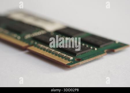 A sharp side-profile shot of a laptop RAM module on white. Focuses on the thickness of the PCB and the soldering details of the connector pins. Stock Photo