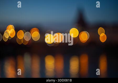 A blurred image of an illuminated city in the evening. Abstract bokeh circles of the out-of-focus city image. Bright circles. Stock Photo