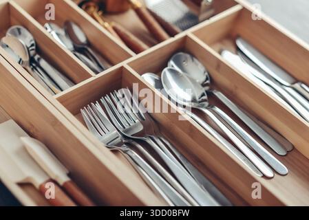 Bamboo box with cutlery in drawer, closeup. Kitchen utensils storage. Stock Photo