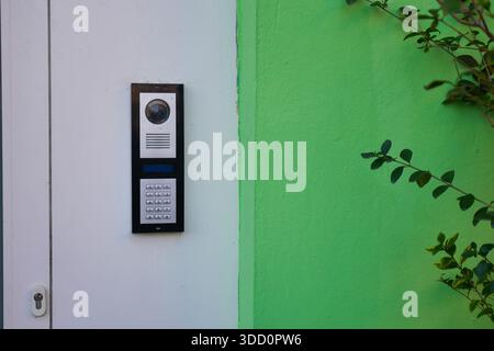 Door intercom on green wall near entrance Stock Photo