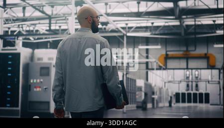 Professional Inspecting IT Infrastructure. Bearded Engineer Walks Between Rows of Servers, Seemingly Conducting Silent Technical Audit of Cloud Architecture. Technical Control and System Integrity. Stock Photo