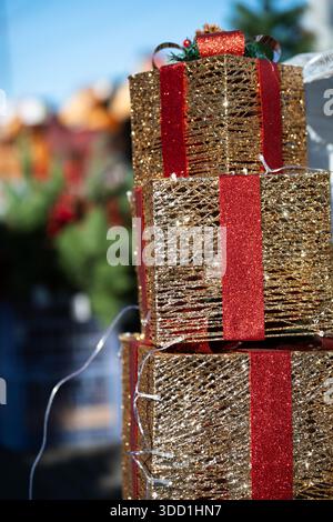 Stack of three gold gift boxes with red ribbons .  Presents for Christmas and New Year Stock Photo
