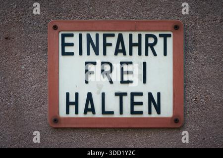 Sign on a house wall with the German inscription Einfahrt freihalten. Translation: Keep driveway clear Stock Photo