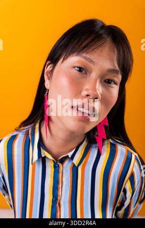 Beautiful chinese woman portrait on colorful background. Young asian woman posing confidently, expressing individuality and fashion with vibrant attir Stock Photo