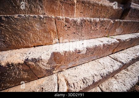 A close-up, downward-angled view of the upper rows of the stepped foundation. The textured, weathered surfaces of the rectangular stone blocks are int Stock Photo