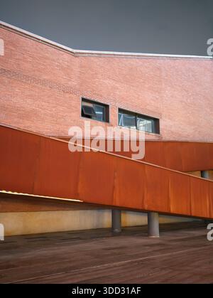 Modern minimalist architecture featuring clean red brick walls and sharp geometric lines under a clear sky. Shot in Wuhan, China Stock Photo