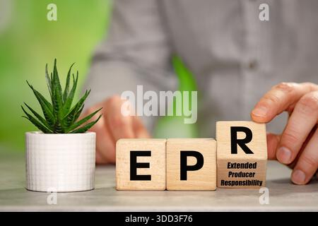 Businessman turns cubes with EPR symbol and reveals slogan Extended Producer Responsibility. A business-environmental concept. Coverage by companies o Stock Photo