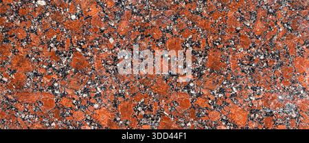 Detailed surface of natural red granite rock forming an abstract background Stock Photo