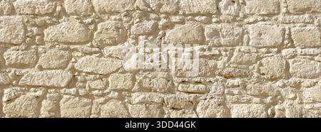 Stone wall showing detail of rough, rustic masonry construction and natural rock texture Stock Photo