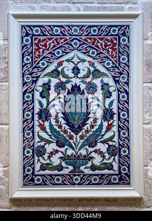Ornate iznik ceramic tile decorating a stone wall, showcasing traditional ottoman patterns Stock Photo