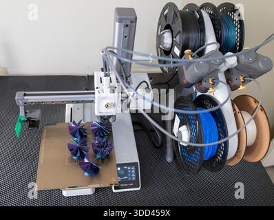 Five complex shaped Christmas decorations during printing on a Bambu Lab 3D printer Stock Photo