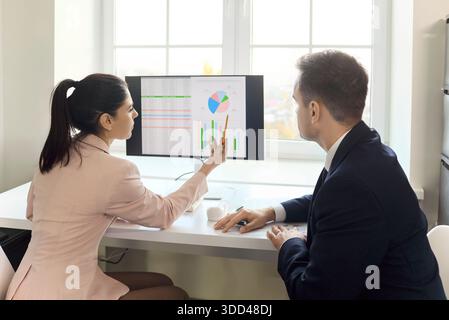 Business colleagues analyzing financial charts on computer during office meeting Stock Photo