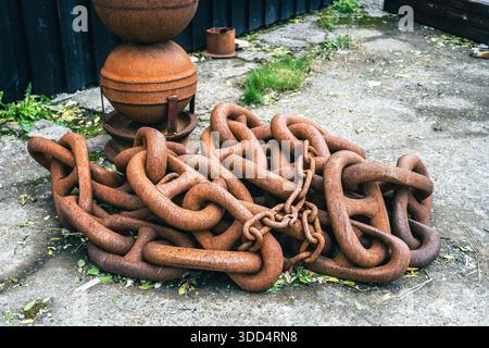 Big rusty chain. Huge naval chain in a port, abandoned instruments, ruined by bad weather. Stock Photo