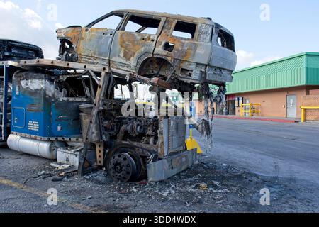 Close up of rusted burnt SUV shell on damaged car carrier trailer Stock Photo