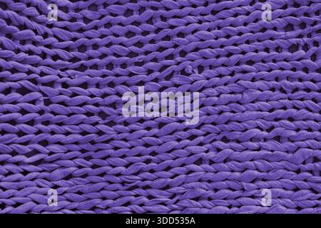 Macro, close up, detailed purple knitted textile, fabric texture with chunky yarn pattern suface. Cozy handmade cloth background, knitwear backdrop , Stock Photo