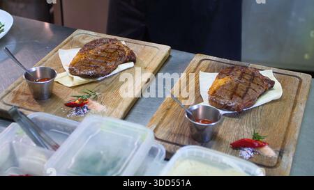 Steakhouse. Steaks are roasted on a Josper oven. The chef serves steaks on wooden boards Stock Photo