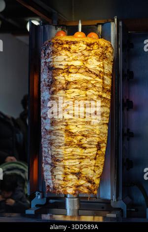 Close-up of a chef slicing traditional Turkish doner kebab meat from a vertical rotisserie Stock Photo