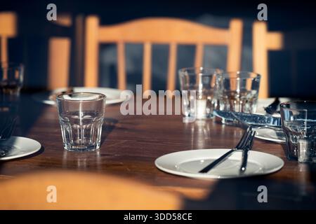 Setting the festive table.  Empty  glasses and plates on wooden table Stock Photo