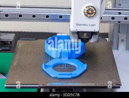 Stock photo of a 3D printer printing a blue plastic cable spool Stock Photo