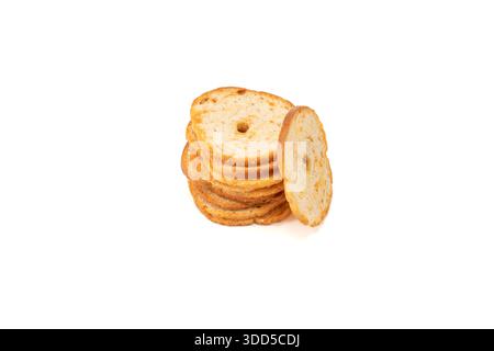 Pile of toasted bread crisps with one slice leaning against the stack. Isolated studio shot highlighting crunchy texture and baked surface, suitable f Stock Photo
