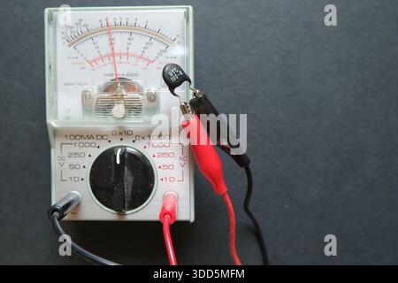 The value of a thermistor (NTC) is measuring with an ohmmeter. Focused on thermistor and probes. Stock Photo