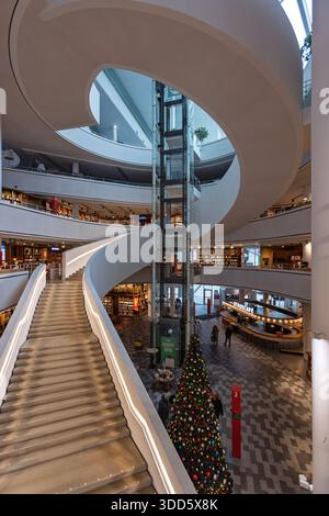 Interior view of the modern Nieuwegein City Hall and library featuring a large spiral staircase, glass elevator, cafe area, and a decorated Christmas Stock Photo