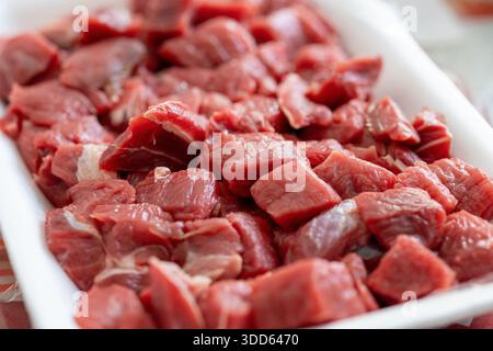 Close-up of fresh raw cubed beef meat pieces on a cutting board Stock Photo