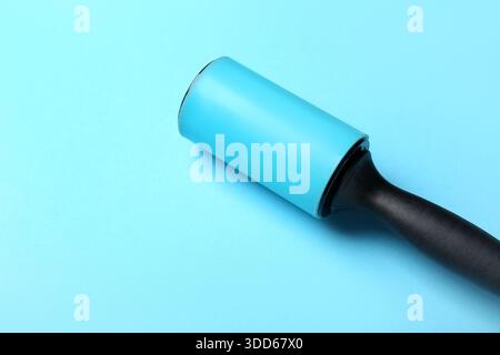 Lint roller on blue background Stock Photo