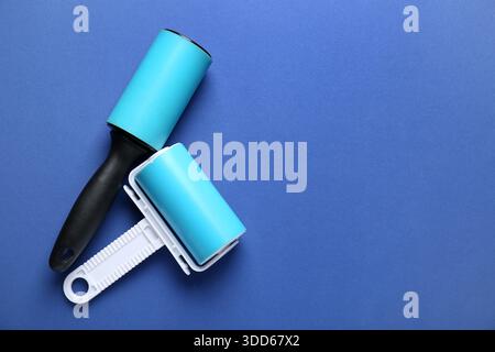 Different lint rollers on blue background Stock Photo