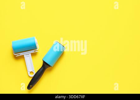 Different lint rollers on yellow background Stock Photo