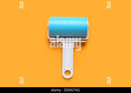 Lint roller on orange background Stock Photo