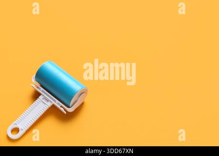 Lint roller on orange background Stock Photo