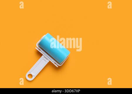 Lint roller on orange background Stock Photo