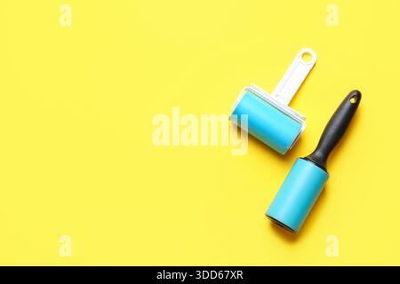 Different lint rollers on yellow background Stock Photo