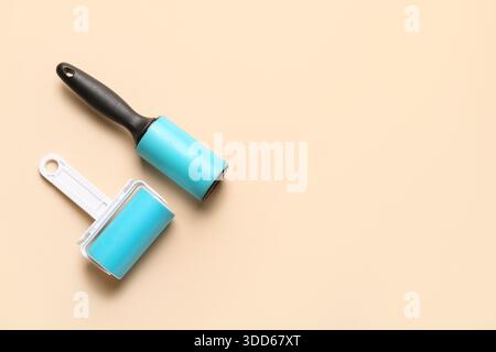 Different lint rollers on beige background Stock Photo