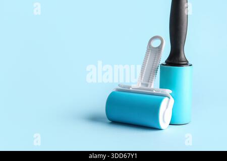 Lint rollers on blue background Stock Photo